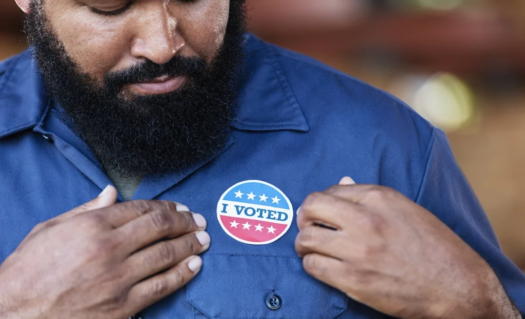 Photo of man admiring his "I Voted" sticker.