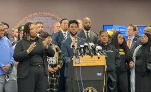 Mayor Brandon Scott and community leaders standing together at press conference.