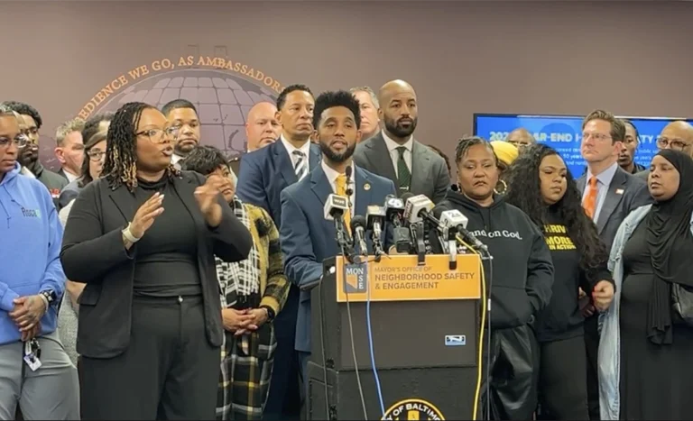 Mayor Brandon Scott and community leaders standing together at press conference.